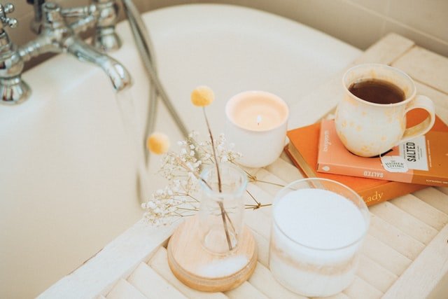 bathtub with a cup of tea and books on the side