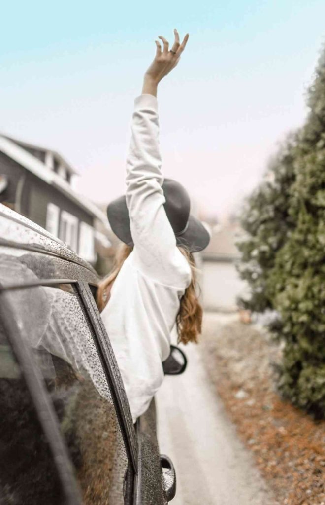 Girl with hands out of car window